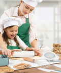 Toy kitchen set for kids with kid-safe knives; front view shows two children in white chef hats and green aprons