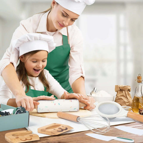 Toy kitchen set for kids with kid-safe knives; front view shows two children in white chef hats and green aprons