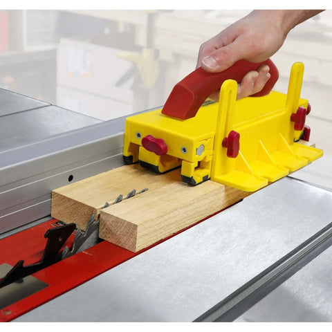 Milescraft 3406 GrabberPRO push block, yellow plastic with red grips, installed on table saw with wood piece.