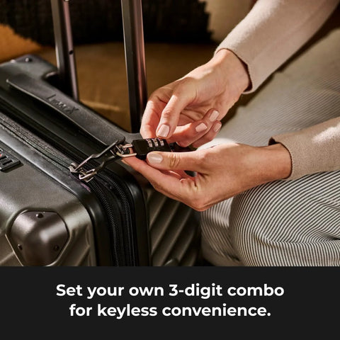 Master Lock black 3-digit combination padlock being attached to a gray hard-shell suitcase