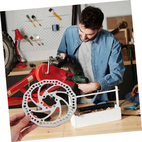 Fire Up Your Rig With This Mountain Bike Front And Rear Mechanical Disc Brake Kit Featuring Forged Aluminum Calipers Premounted Pads And Direct Pull Cables For Solid Stops On Wild Trails All Season Long, showing silver disc brake in workshop.