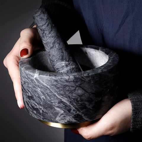 Person holding Granite Mortar And Pestle Set With Gold Metal Base 2 Cup Capacity For Making Fresh Guacamole Salsa Pesto And Spices