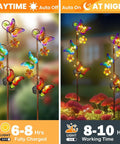 Butterfly Solar Stake Lights 2 Pack Waterproof Outdoor Decor For Garden Lawn Patio Courtyard With Warm Yellow LED Glow Wrapped Around Butterfly Design Solar Powered Landscape Pathway Lights For Nighttime Ambiance, showing daytime and nighttime views.