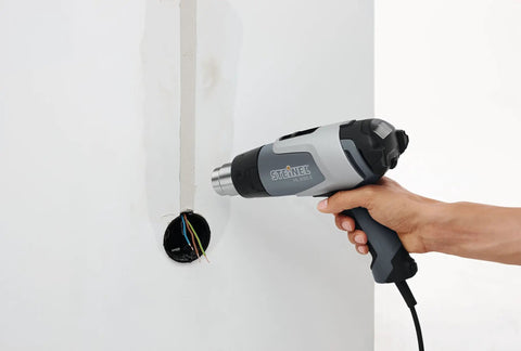 Hand using HL 2020 E Pro Grade Heat Gun With LCD Display 1600 W Hot Air Tool for wire work, adjustable temperature, 1.34 inch nozzle.