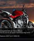 Motorcycle with red body, black frame, and exposed engine at sunset.