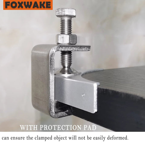 Front view of stainless steel mini C-clamp (1 inch) with protective pad clamping onto a desk edge.