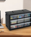 Top Shelf Nine Drawer Plastic Storage Cabinet With Easy Adjust Dividers For No Sweat Organization Small Parts Sorting Craft Supplies And Wall Mount Desktop Tool Box placed on a desk next to a laptop.