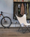Rakk Bike Storage Rack Freestanding Floor Bicycle Stand For Small Spaces Ideal For Apartments, Garages, Basements, Sheds, And Shops Keeps Bikes Organized And Easy To Access next to modern chair.