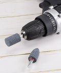 Pro Grade Fifteen Piece Abrasive Mounted Stones Set With One Quarter Inch Shank And One Inch Cylindrical Corundum Grinding Heads shown on a drill