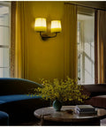 Industrial Battery Powered Wall Sconce With Two Light LED Fixture on a living room wall with yellow fabric shades