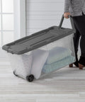 Person using 4 Pack Modular Stacker Box Set Of Durable Clear Plastic Storage Bins With Latching Lids 160 Quart Capacity