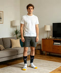 Man in living room wearing Crazy Colorful Mens Dress Socks For Men Size 8 To 12 Crew Length Dope Patterned Dress Socks with colorful stripes.