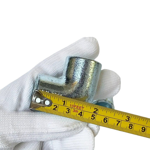 Close-up of 4 Pack 1/2 Inch Galvanized Pipe Fittings 90 Degree Elbows Malleable Iron Slip On Connection in hand with measuring tape
