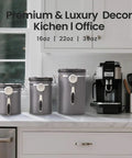 Three airtight stainless steel coffee canisters 39oz, 22oz, 16oz on a kitchen counter with a coffee machine.