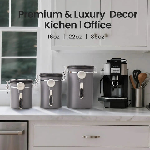 Three airtight stainless steel coffee canisters 39oz, 22oz, 16oz on a kitchen counter with a coffee machine.
