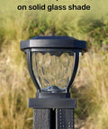 Solar Post Cap Lights With Decorative Glass LED Outdoor Post Lighting For Three And A Half Inch Posts Black Two Pack Weatherproof Pathway Vibe Long Lasting Warm LED Lighting For Nighttime Safety And Curb Appeal with glass detail against a garden background.