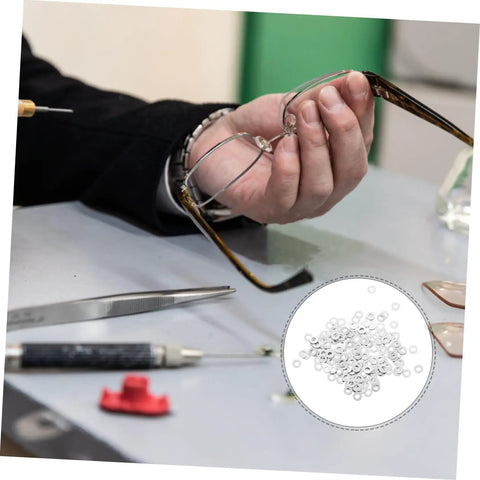 Person using 200-Piece Eyewear Repair Kit With Metal Spacers And Washers For Quick Eyeglass Frame Repairs on rimless glasses.