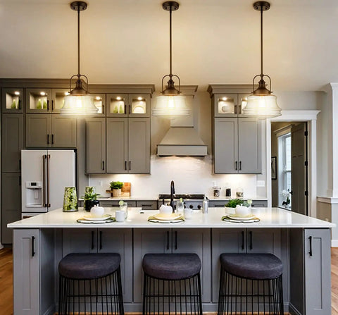 Three Black Farmhouse Pendant Light With Clear Glass Schoolhouse Style fixtures above a modern kitchen island with gray cabinetry.