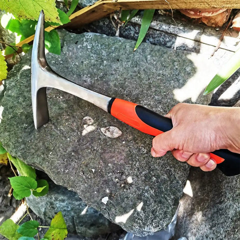 Hand using Heavy Duty 28 Oz Rock Pick And Brick Hammer With Pointed Tip And Flat Head Forged Steel Construction for stone work
