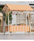 Heavy Duty Portable Folding Vending Cart With Locking Wheels Perfect For Street Food And Coffee Sales Featuring Sturdy Wood Frame And Waterproof Cover, decorated with striped awning and lights.