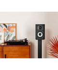 XT15 Monitor Bookshelf and Surround Sound Speakers Pair with Hi Res Audio Certified in a living room setting on a stand