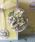 Yellow handmade card with 3D floral frame, greenery, and 'Happy Birthday Nan 76' text created using metal die cuts and embossing dies.