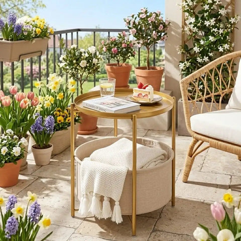 Round End Table With Removable Fabric Storage Basket And Tray Top, Gold Metal Nightstand outdoors surrounded by flowers on patio