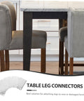 Solid As A Rock Heavy Duty Iron Furniture Leg Conversion Brackets For Couches And Tables mounted under a table with grey chairs.