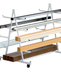 Heavy Duty Lumber Storage Rack On Wheels 5ft By 3.7ft By 4.3ft Rugged Alloy Steel Build That Lasts Easy To Move On Four Heavy Duty 3 Inch Swivel Casters Ideal Garage Workshop Go To Lumber Organization, showing multilevel metal frame loaded with wooden planks and metal rods.