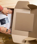 Hands using 12 Pack Corrugated Paper Filler Sheets for Moving and Shipping Cut to Size Cardboard Padding in a box.