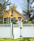 White vinyl gate with 36 Inch Cane Bolt Gate Drop Pin And Drop Rod in front of a yellow house with green shutters and garden