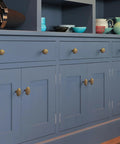 Six Pack Zinc Alloy Drawer Knobs in Big Oval Antique Brass Finish for Cabinets and Furniture shown on blue kitchen cabinets.