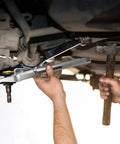DURATECH 5-piece ball joint separator set in silver metal being used under a car by a mechanic.