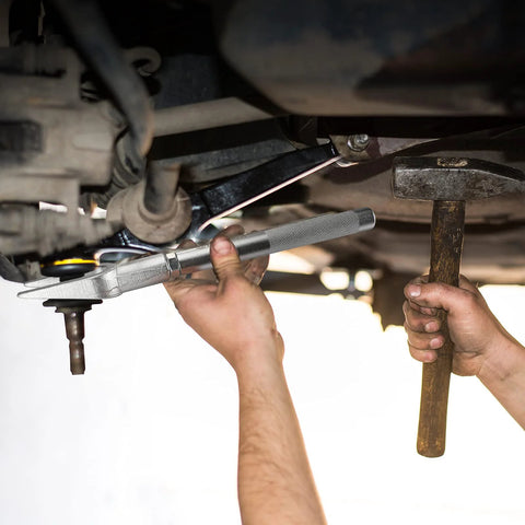 DURATECH 5-piece ball joint separator set in silver metal being used under a car by a mechanic.