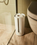 Birillo Toilet Paper Roll Container White Designer Bath Accessory By Piero Lissoni In PMMA Plastic beside toilet in bathroom