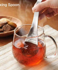Ginger Grater Spoon And Lime Zester With Garlic Press And Wasabi Grinder used to mix tea in glass mug on table