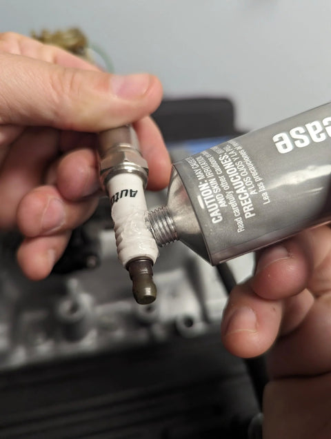 Permatex dielectric tune-up grease, 3 oz, shown being applied to a spark plug boot terminal.