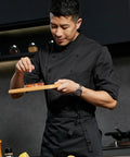 Men Half Sleeve Chef Coat In Soft Black Lightweight Stretch Jacket Breathable Kitchen Uniform on chef seasoning meat.