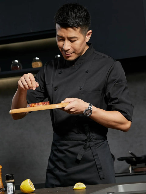 Men Half Sleeve Chef Coat In Soft Black Lightweight Stretch Jacket Breathable Kitchen Uniform on chef seasoning meat.