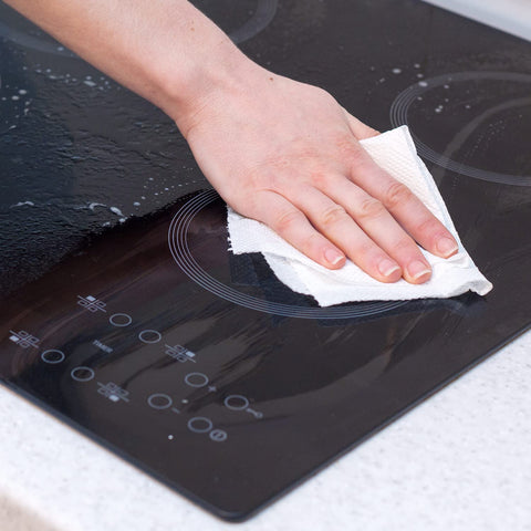 Hand cleaning a glass stovetop with Heavy Duty Cleaning Wipes 260 Count Bulk Pack With Dual Texture For Hands And Surfaces Remove Paint Adhesives Oils Grease And Dirt Grime Busting Safe On Skin With Aloe Vera And Vitamin E