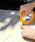 Hands applying Four Pack Painters Tape Set With 1/16, 1/8, 1/4 And 1/2 Inch Widths, 52 Yards Each on a surface for automotive DIY masking.
