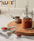 Six Piece Stainless Steel Measuring Spoons Set For Cooking And Baking Includes One Eighth Teaspoon displayed with spices on table