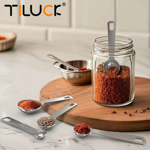 Six Piece Stainless Steel Measuring Spoons Set For Cooking And Baking Includes One Eighth Teaspoon displayed with spices on table