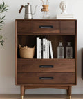 Mid-century modern wooden cabinet with books, basket, and glass bottles, accented by plants and decorative items on top.