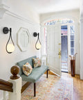 Modern Globe Wall Sconce Set Of 2 Black Glass Drop Lights illuminating a hallway with frosted glass ball and minimalist water drop design