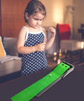 Child playing with Indoor Mini Golf Mat With Auto Return System For Home And Backyard Practice in living room