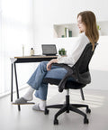 Person sitting on Ergonomic Office And Gaming Chair With Lumbar Support And Breathable Mesh Back Adjustable Height Swivel Rolling Wheels Flip Up Arms For Space Saving Boss Level Comfort At Home Or Vanity Black.