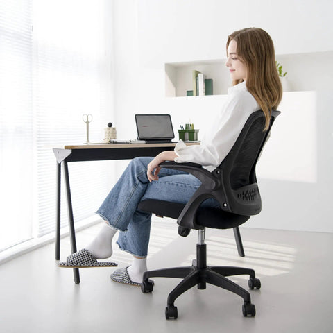 Person sitting on Ergonomic Office And Gaming Chair With Lumbar Support And Breathable Mesh Back Adjustable Height Swivel Rolling Wheels Flip Up Arms For Space Saving Boss Level Comfort At Home Or Vanity Black.