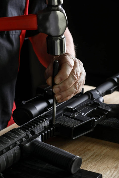 Person using Heavy Duty Built To Last Pro Grade 16 Piece Punch And Chisel Set with tapered punch on a firearm.