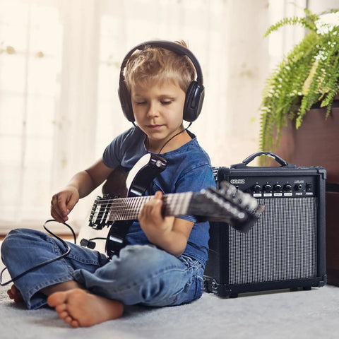 Child playing guitar with 20 Watt Portable Electric Guitar Amplifier With Headphone Input And Gain Control For Quiet Practice